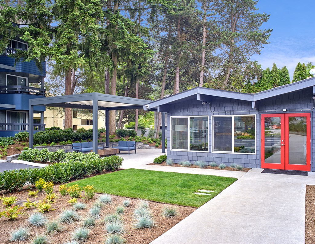 Exterior view of leasing office. Manicured garden and lawn in front of office. Office is blue with a red door and path to the front door. at 3030 Lake City, Seattle, Washington