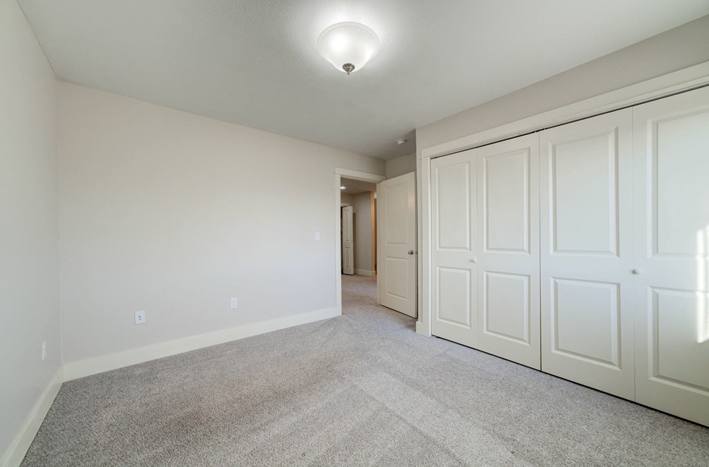 a bedroom with two closets and a carpeted floor at Copper Pines, Bozeman, MT