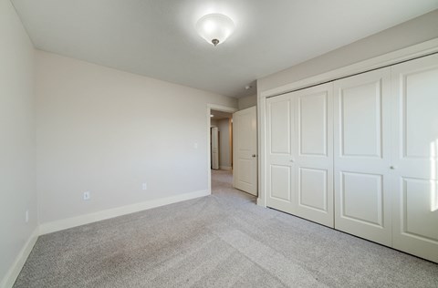 a bedroom with two closets and a carpeted floor at Copper Pines, Bozeman, MT