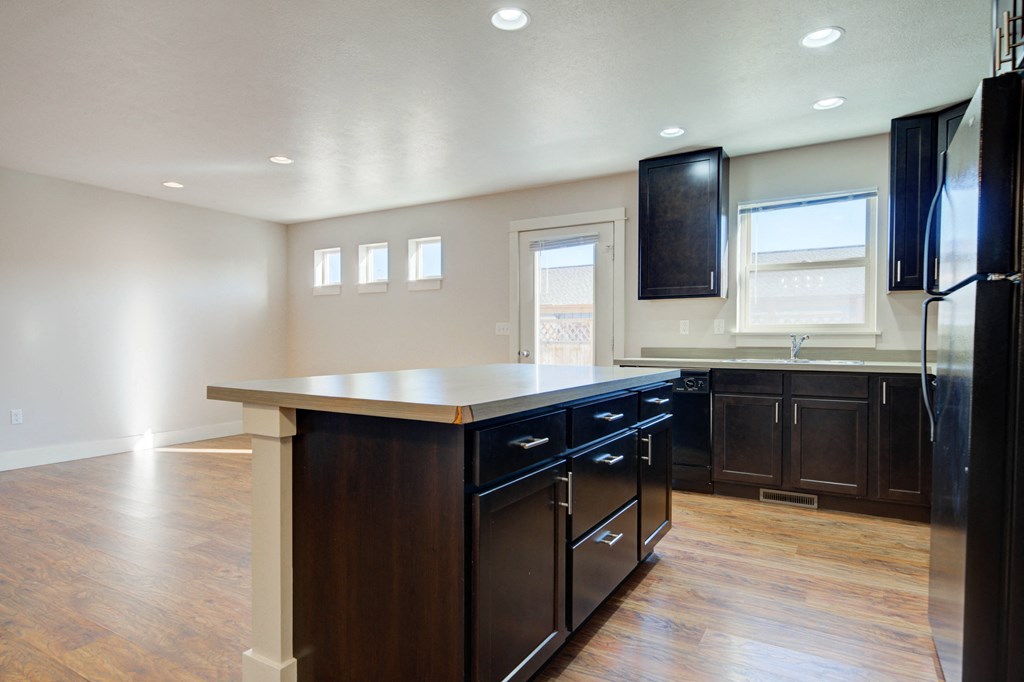 a kitchen with a center island and a black refrigerator at Copper Pines, Bozeman, MT, 59718
