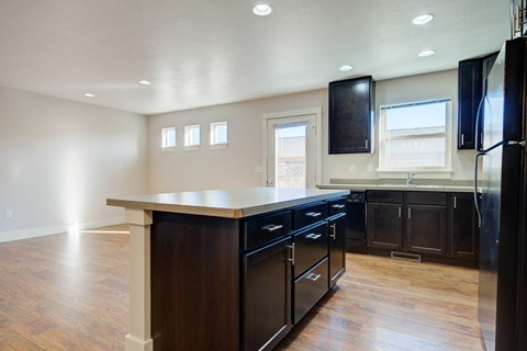 a kitchen with a center island and a black refrigerator at Copper Pines, Bozeman, MT, 59718