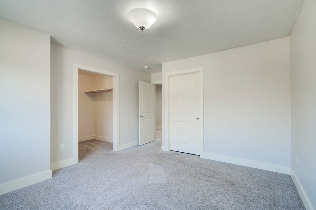an empty living room with white walls and white doorways at Copper Pines, Bozeman, MT