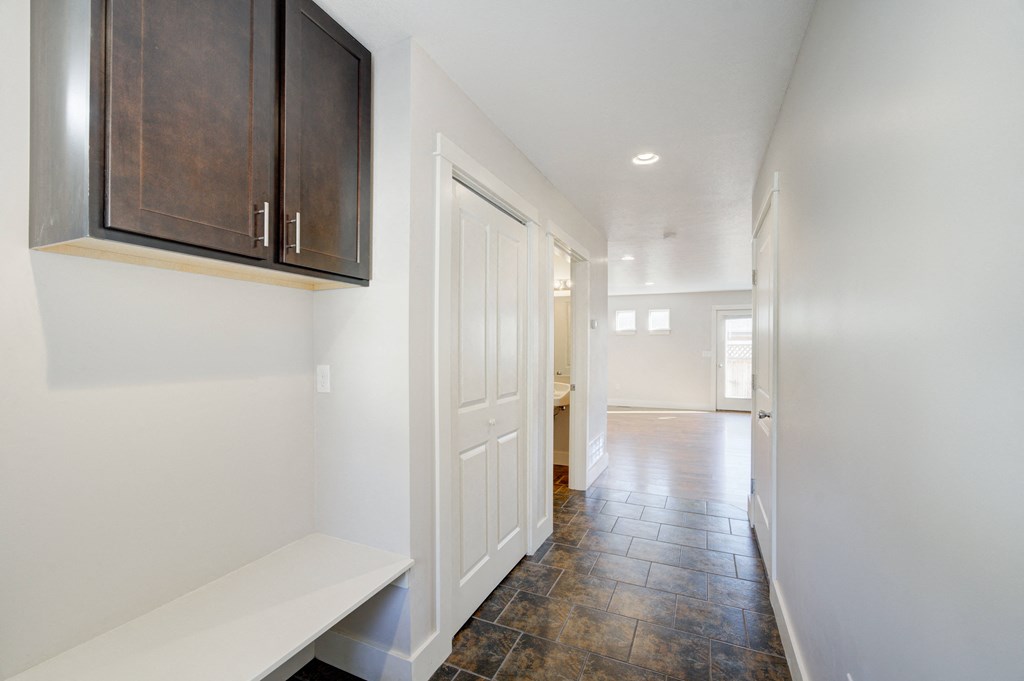 a entryway with a white door and a hallway with a door to a kitchen at Copper Pines, Montana