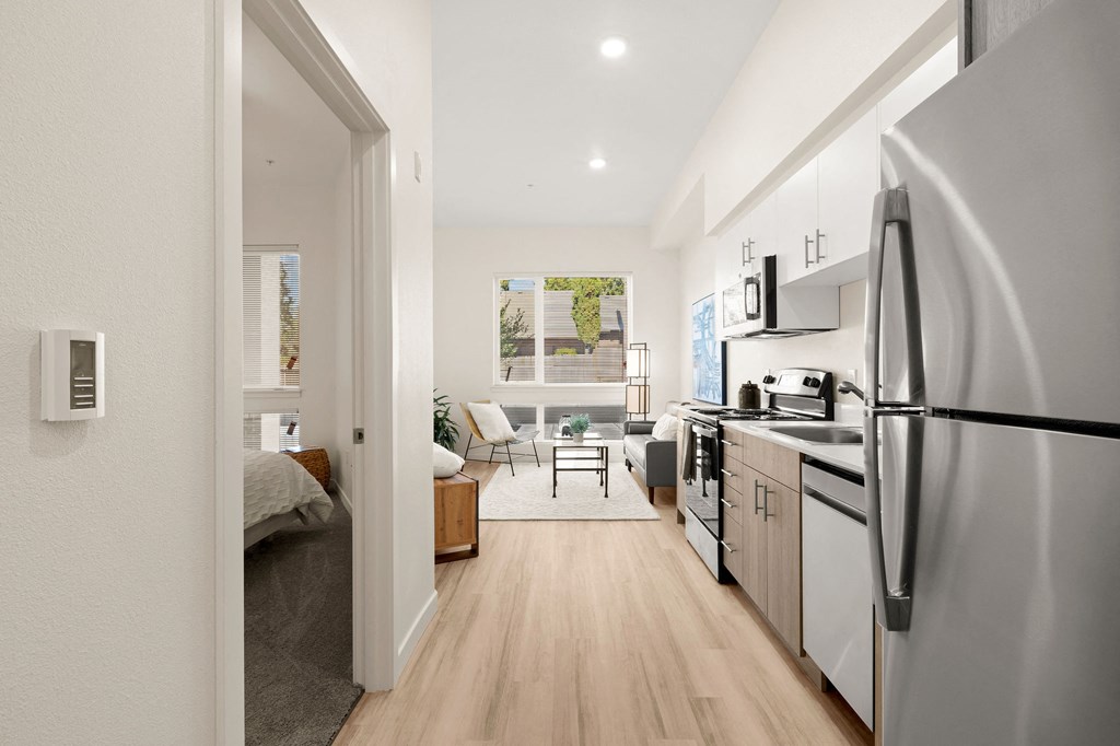 an open kitchen and living room with a refrigerator and stove at The Duo, University Place, 98466