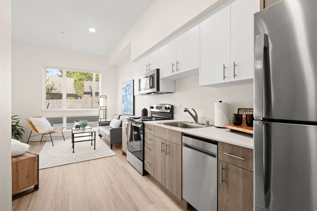 a kitchen with stainless steel appliances and white cabinets at The Duo, Washington