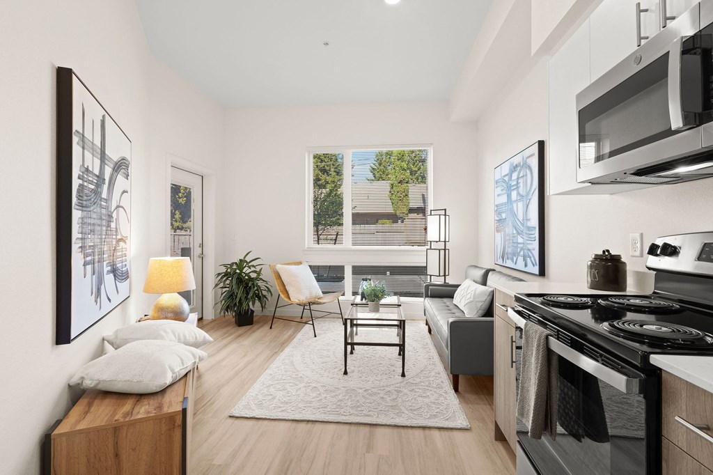 a living room with a kitchen and a large window at The Duo, University Place Washington