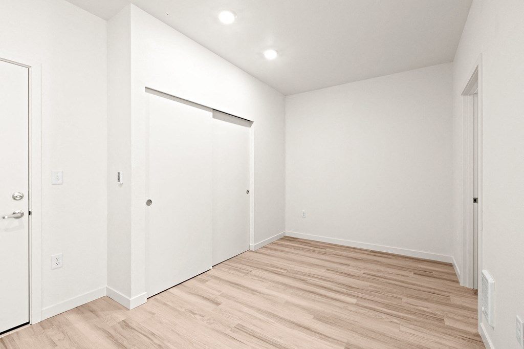 a living room with white walls and a wood floor at The Duo, University Place