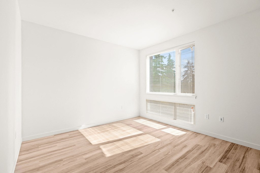 a living room with a large window and wooden floors at The Duo, University Place, WA