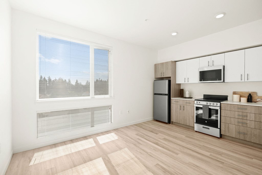 a kitchen with a stove refrigerator and a window at The Duo, Washington, 98466