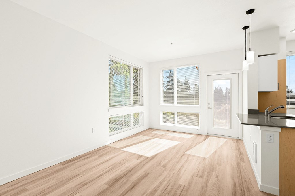 a living room with a kitchen and a large window 