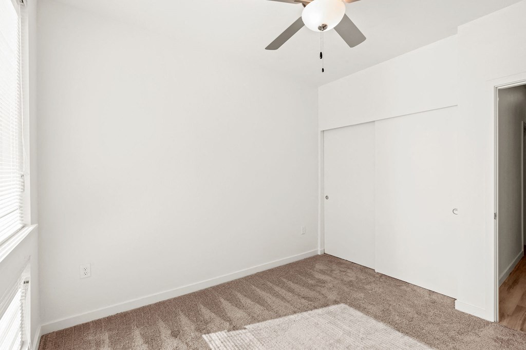 a living room with white walls and a ceiling fan at The Duo, Washington