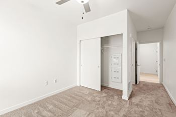 an empty bedroom with white walls and a ceiling fan  at The Duo, University Place, WA 98466
