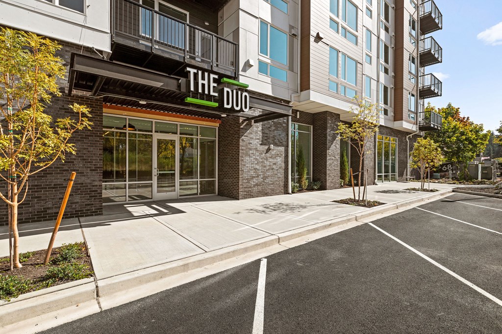 a parking lot in front of a building with a sign on the side of it at The Duo, University Place