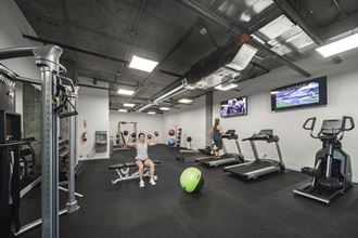 Gym with treadmills, an elliptical, weight machines, free weights, benches, an exercise ball and tvs - Photo Gallery 5