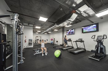 Fitness center Gym with treadmills, an elliptical, weight machines, free weights, benches, an exercise ball and tvs - Photo Gallery 2
