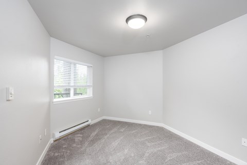 Spacious 1 bedroom apartment bedroom with plush carpet and natural light at 6Wood Flats Apartments in Lacey Washington