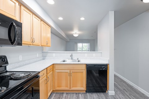 Updated kitchen with black appliances and wood cabinets in a 1 bedroom apartment at 6Wood Flats Apartments in Lacey Washington