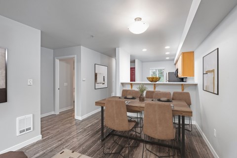 A dining room with a table and chairs.