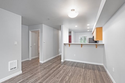 Open concept living and dining area with wood style flooring at 6Wood Flats Apartments in Lacey Washington