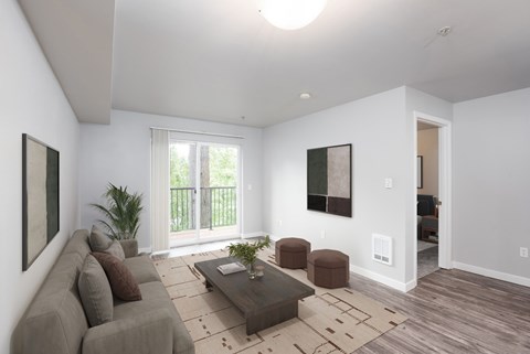 A living room with a couch, coffee table, and two potted plants.