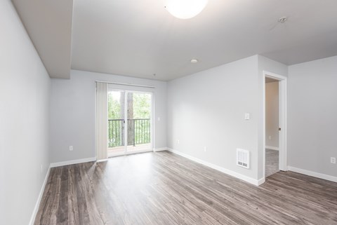 Bright apartment living room with large windows and wood style flooring at 6Wood Flats in Lacey Washington
