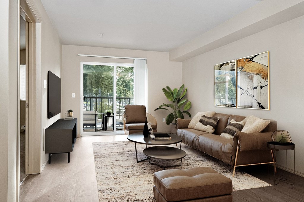 Living room with sliding glass door to the balcony on the far wall, matching chair, couch, and ottoman with a table in the center across from a tv and entertainment unit at 6 Wood Flats, Lacey, WA 985