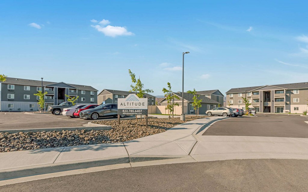 Exterior view of community buildings and parking lot. Bright blue sky and well-maintained landscaping. at Altitude, East Wenatchee