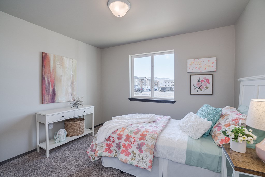 Bedroom with accent table, window and full size bed. at Altitude, East Wenatchee, Washington