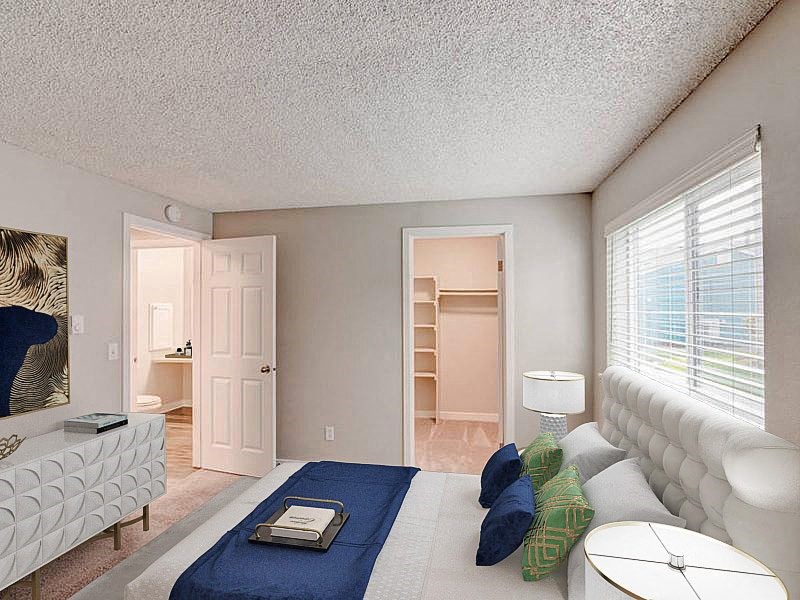A bedroom with a spacious closet on the back wall and an oversized window above the queen-size bed. at Pointe East, Fife, WA, 98424