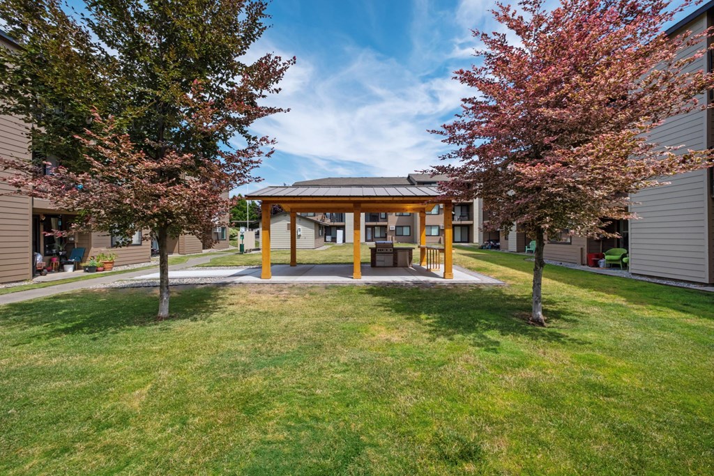 a covered area in the middle of a grassy area with trees on either side at Brix, Washington, 99362