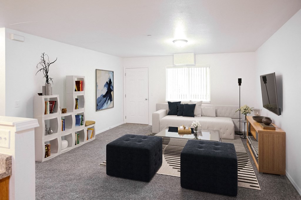 Bright living room with taupe carpet, white walls and door and window at opposite end.at Canyon View, Idaho, 83501