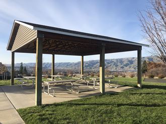 Outdoor community pavilion with many benches surrounded by grass and overlooking the Snake River mountain range.at Canyon View, Lewiston Idaho - Photo Gallery 3