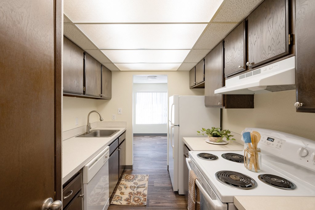 a kitchen with white appliances and wooden cabinets and a white stove and refrigerator
