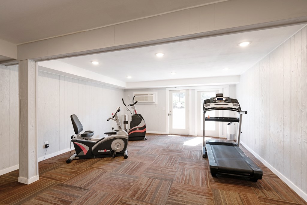 a gym with stationary bicycle, ellyptical machine and treadmill at Castlerock Apartments
