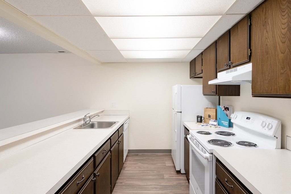 the preserve at ballantyne commons apartment kitchen with white appliances and wood cabinets