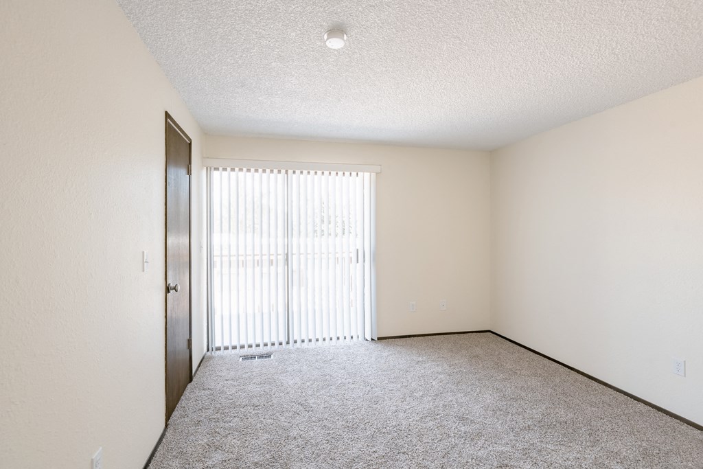 an empty living room with a sliding glass door