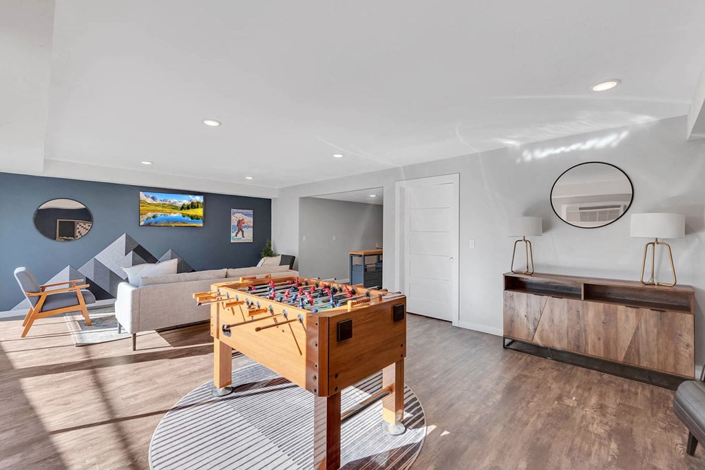 Clubhouse with wood floors, seating area, mounted TV, and a foosball table. at Castlerock, Wenatchee, WA 98801