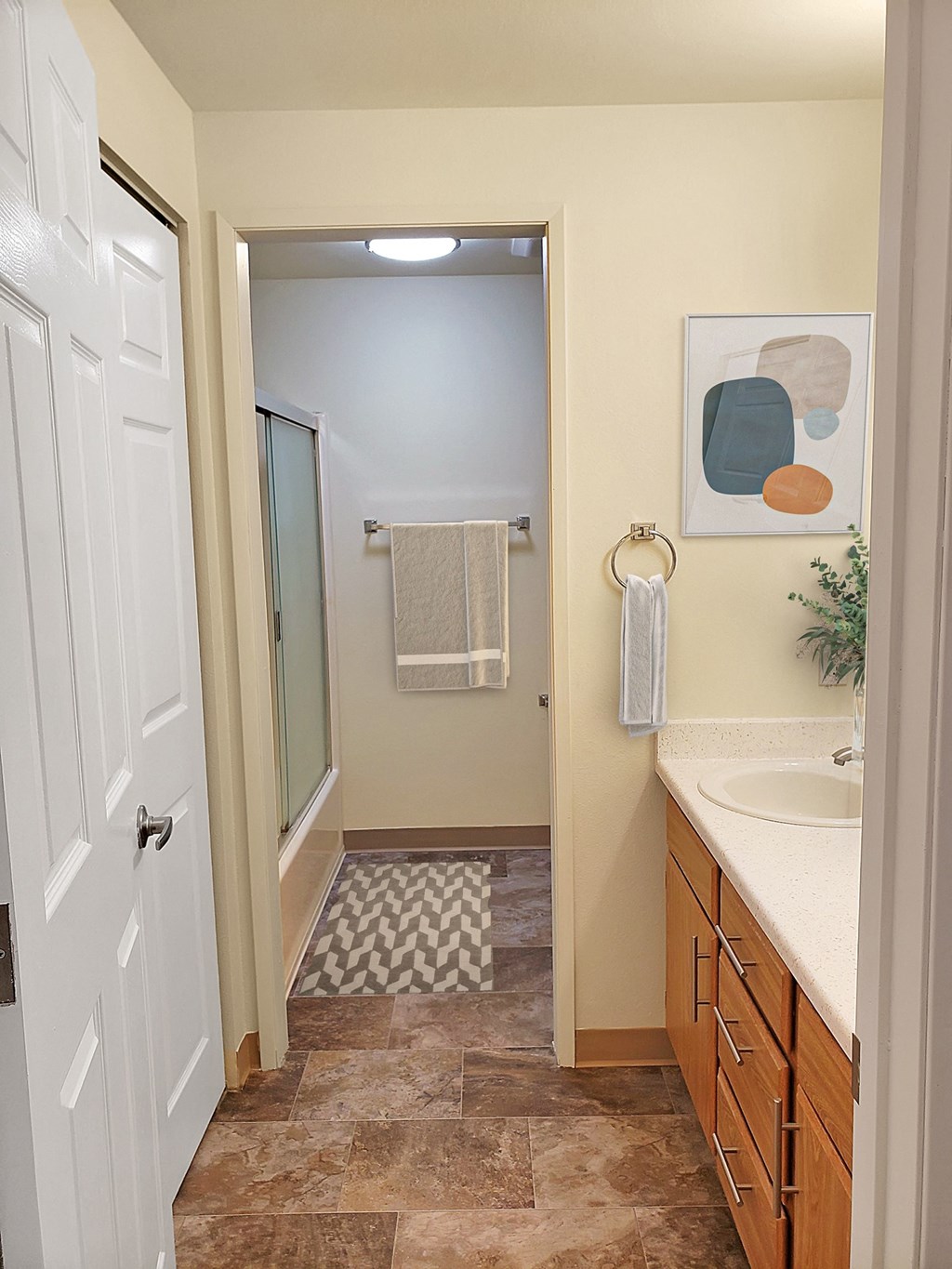 Full bathroom with a closet across from sink and sink cabinets, past sink is a toilet and shower with sliding glass doors.at Clearwater, Idaho
