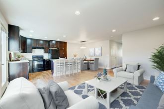 a living room and kitchen with white couches and a table
