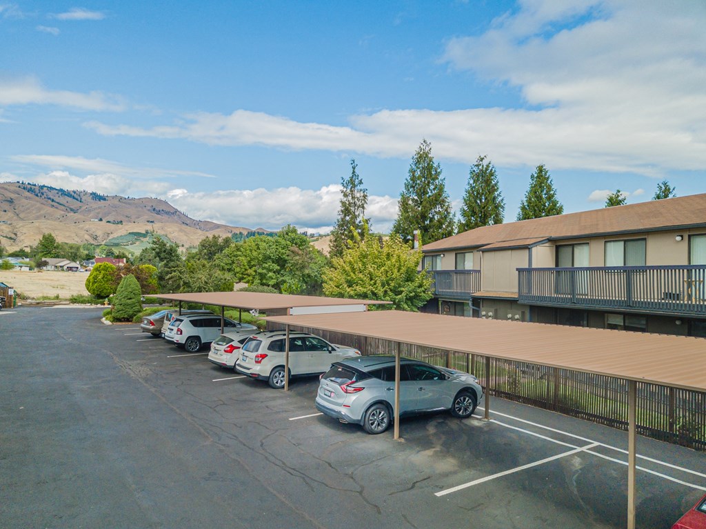 a parking lot with cars parked in front of a hotel building at Cedarwood, Washington