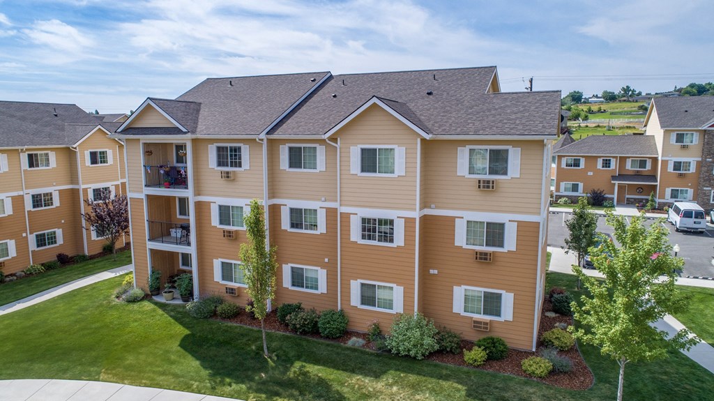 an aerial view of an apartment building with green grass and trees. apartment in Richland, WA