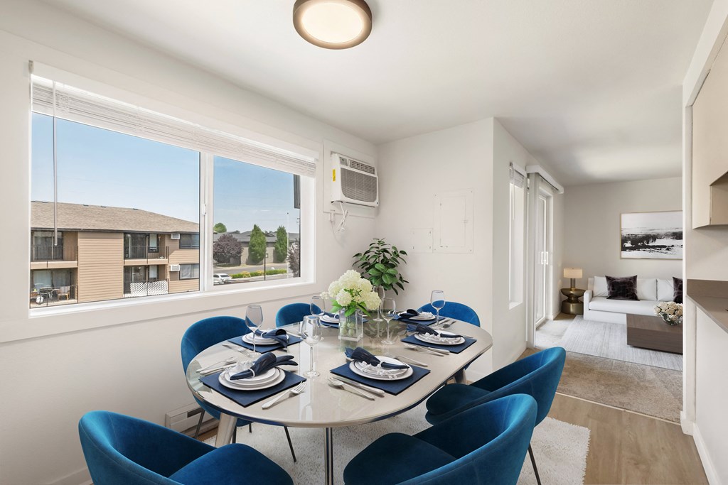 a dining area with a glass table and blue chairs and a large window with a view of  at Brix, Washington, 99362