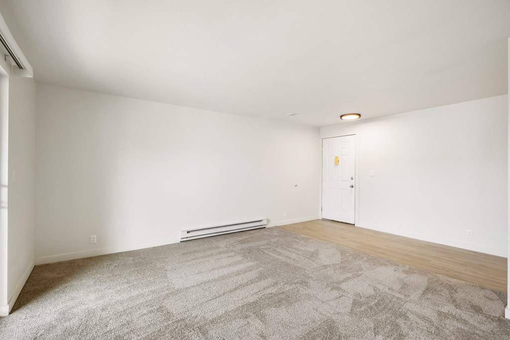 a living room with carpet, faux wood floors and white walls  at Brix, Washington