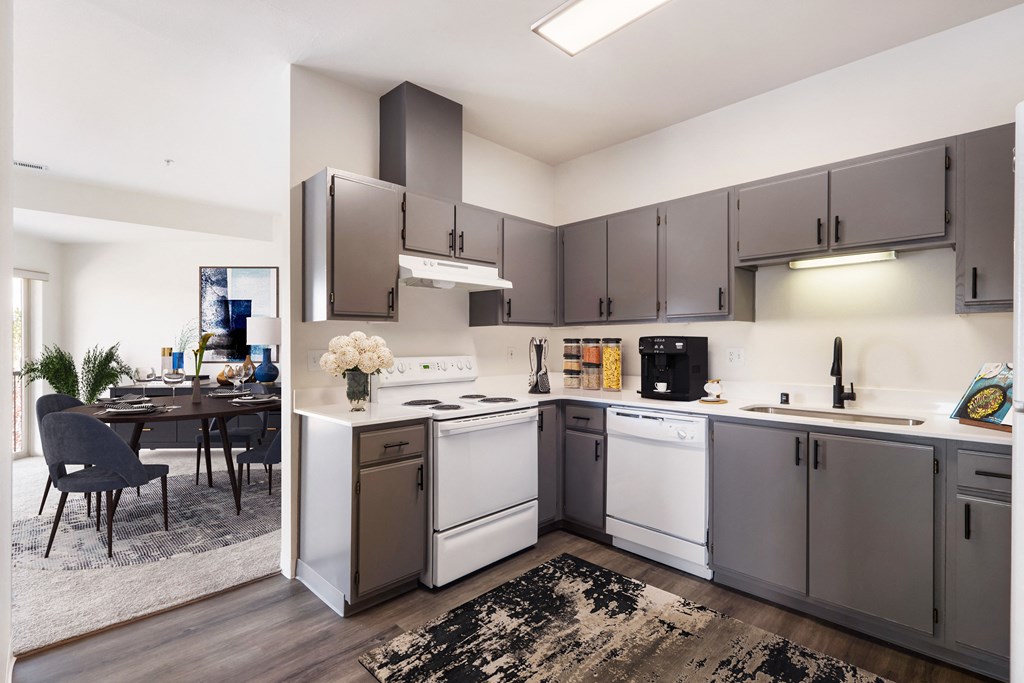 L-shaped kitchen with white appliances, gray cabinets and the dining room behind.at Shoreline Village, Richland