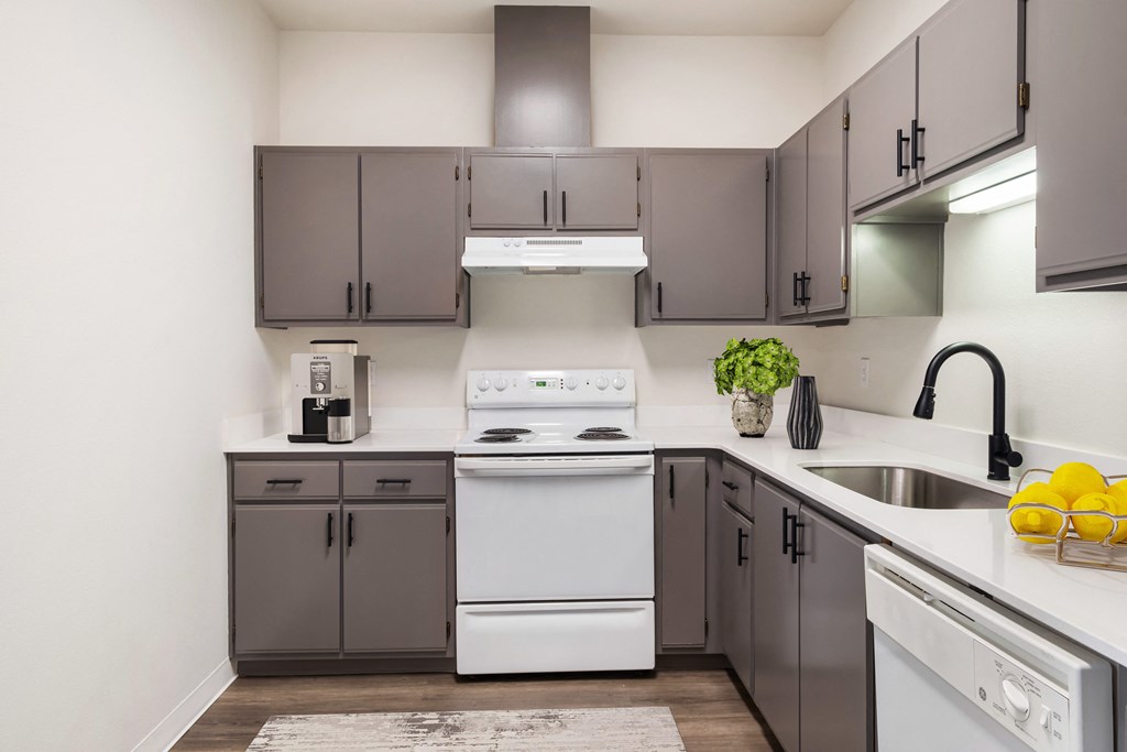L-shaped kitchen with ample cabinet storage, white appliances and white countertops.at Shoreline Village, Washington, 99352