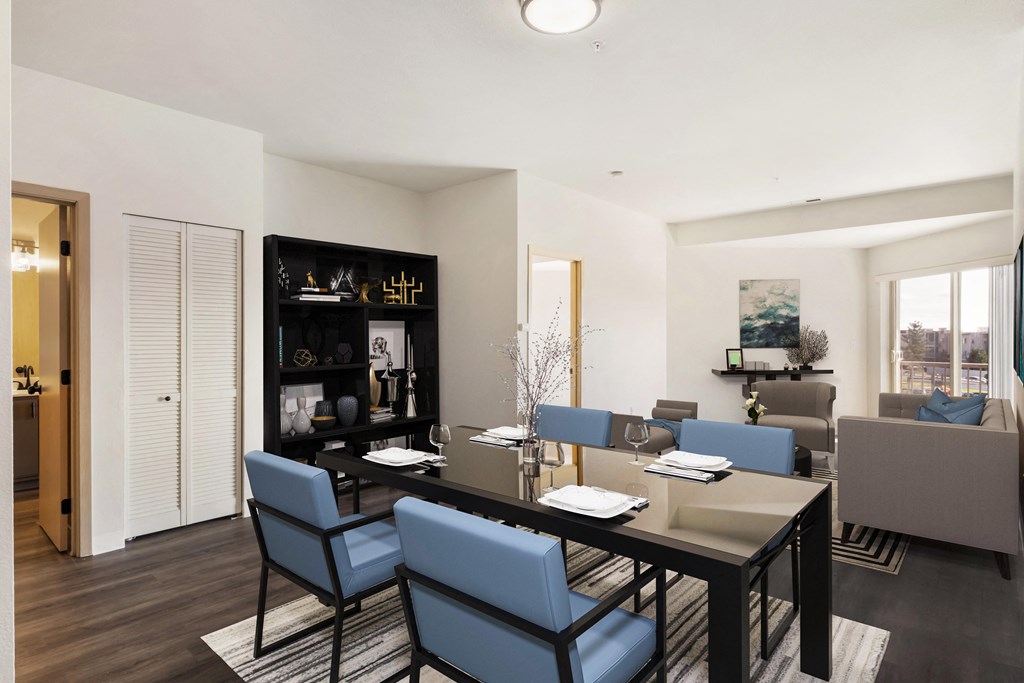 a dining room with a table, 4 blue chairs and the living room behind.at Shoreline Village, Richland, 99352