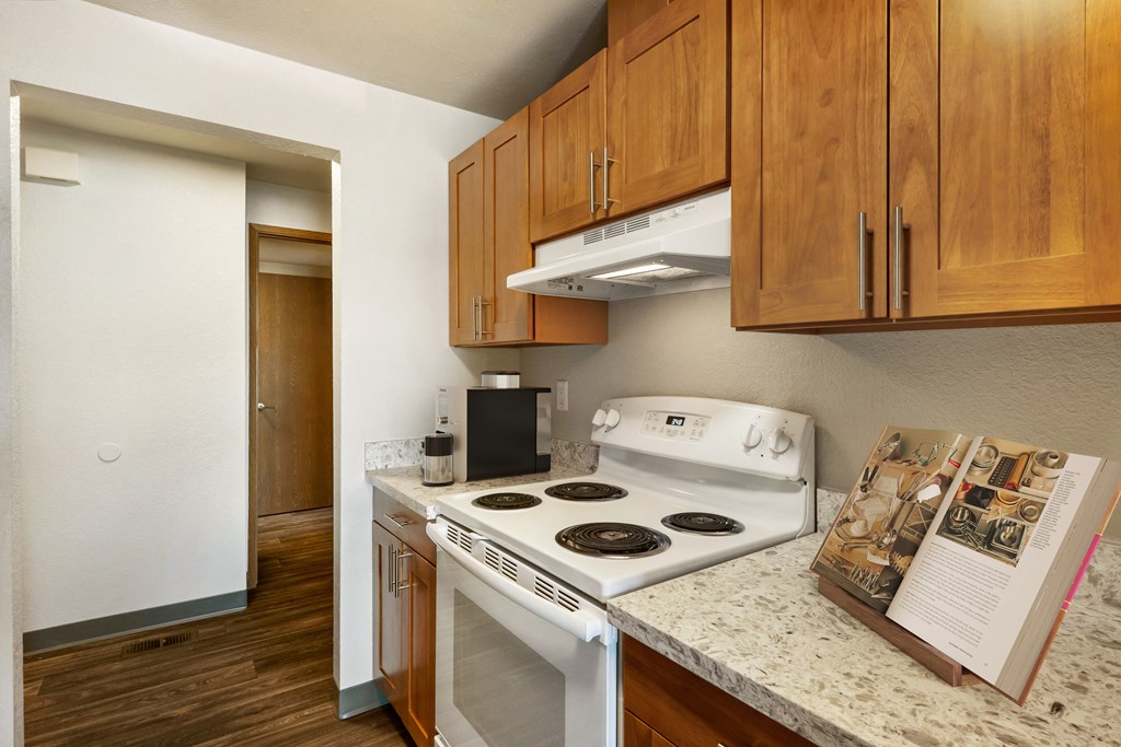 a kitchen with white appliances and wood cabinets  Kitchen at Cedarwood, Washington