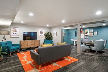 Resident clubhouse with seating, a flat screen TV, and game room at apartments in Wenatchee.
