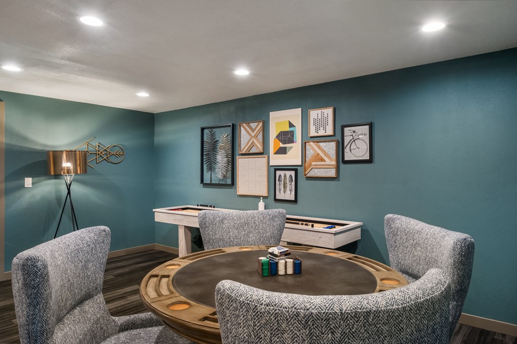 a game room with blue walls and a round table with three chairs at Cedarwood, Wenatchee, WA 98801