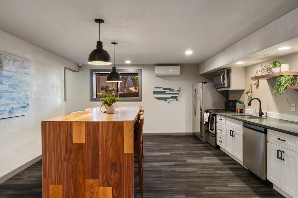 a kitchen with white cabinets and a wooden island with a vase of flowers on it at Cedarwood, Wenatchee, WA